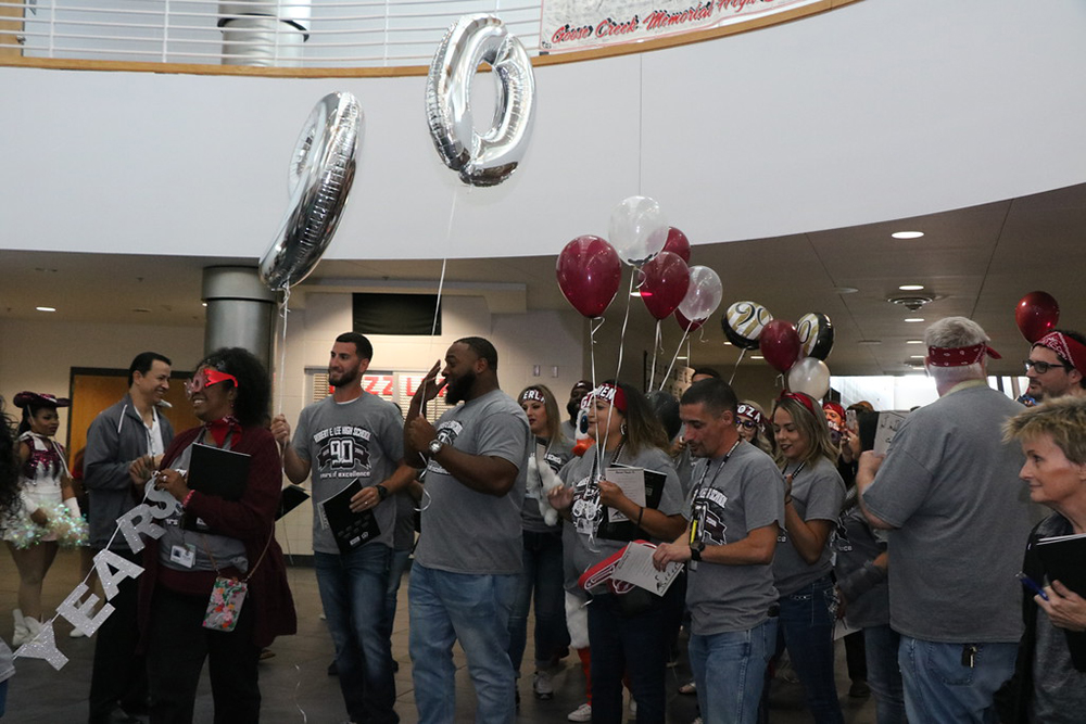 
Robert E. Lee High School faculty and staff members charge into the recent back-to-school convocation, celebrating the 100th anniversary of Goose Creek CISD and the 90th anniversary of REL.
