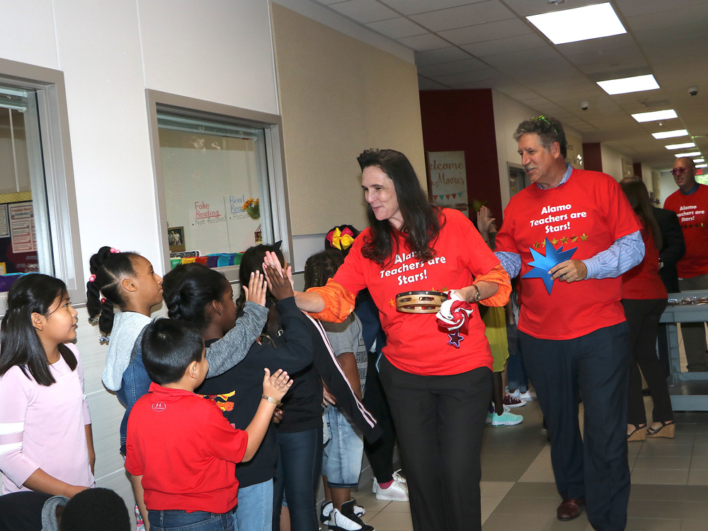 
Dr. Melissa Duarte (front), deputy superintendent for curriculum and instruction, and Randal O’Brien, superintendent, high five Alamo Elementary students and pass out stars to faculty members to recognize Alamo’s six Distinctions on the STAAR. The school received Distinctions for Academic Achievement in  ELA, Math and Science; Top 25 Percent Comparative Academic Growth; Top 25 Percent Comparative Closing the Gaps and Postsecondary Readiness. Pictured are (from left) Saytonya John, Lionzo Alaniz, Aquilla Edward and (back) Chanilah Rivera.
