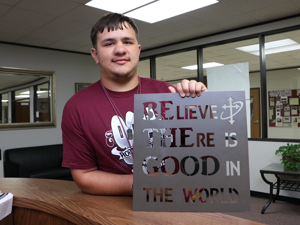 
Billy Haynes, a defensive lineman for the Robert E. Lee High School Ganders, displays the gift given to the school by Santa Fe High School before their recent football game.
