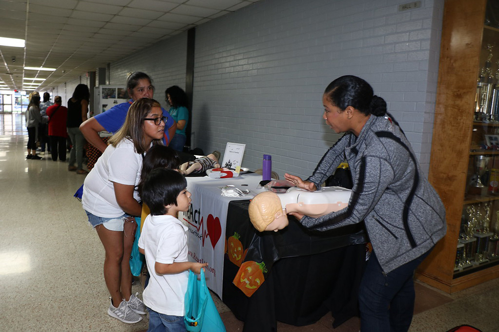 
Camille Gomez (right) from ReAct In A Heartbeat shows (from left) Odelia Cabrera, Leanora Cabrera, Adrian Lucatero, first-grader, and Anthony Lucatero, kindergartener, both at Bowie Elementary, choking prevention and CPR. ReAct was one of more than 50 vendors at the Goose Creek CISD Parent Resource Fair
at Ross S. Sterling High School.
