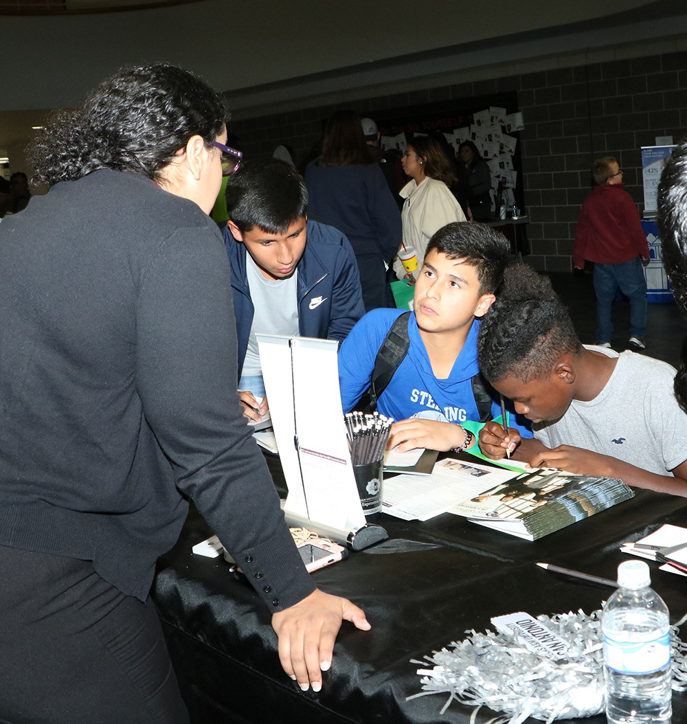 
Ross S. Sterling High School  AVID students (from left) Eydris Marquez, Julio Garcia and Jeele Joseph ask Melissa Morales with ATM San Antonio questions about the college experience during Goose Creek CISD’s annual College Night for all district students at Goose Creek Memorial High School.
