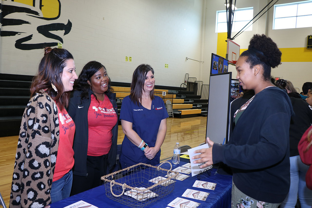 
Layla Jennings (right), eighth-grader at Highlands Junior School, discusses her interest in the medical field with Patients ER staff (from left) Ashley Shibley, marketing coordinator; Whitley Dorsett, assistant marketing coordinator, and Tonya Smith, registered nurse, at the recent Third Annual Highlands Junior School College and Career Fair. Jennings and her eighth-grade classmates will make decisions about their endorsements for high school in the next few weeks.
