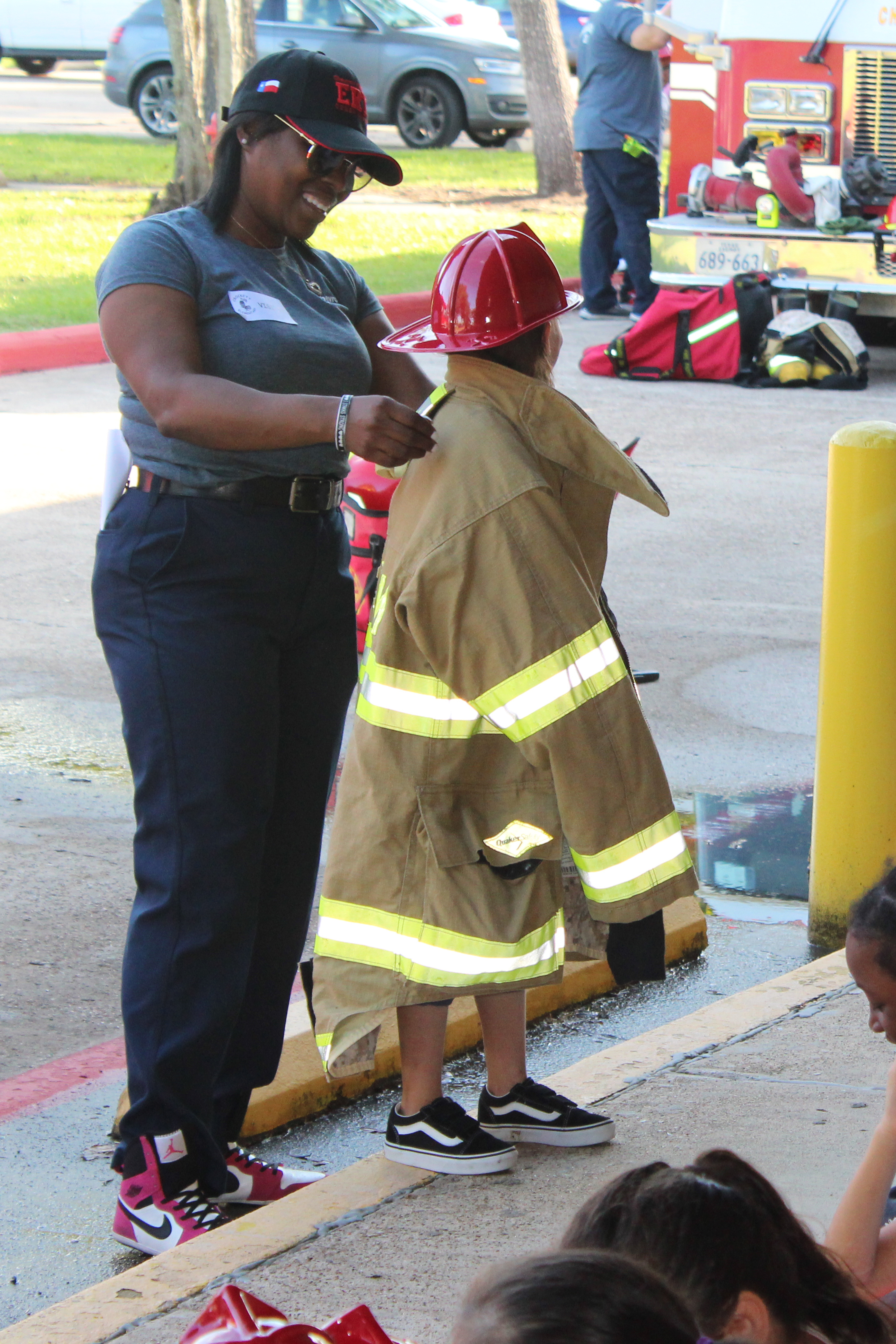 
Yanique Messitho, a process operator and volunteer emergency response team member for Chevron Phillips Chemical, helps a Crockett Elementary student try on a firefighting jacket during Fire Prevention Week.
