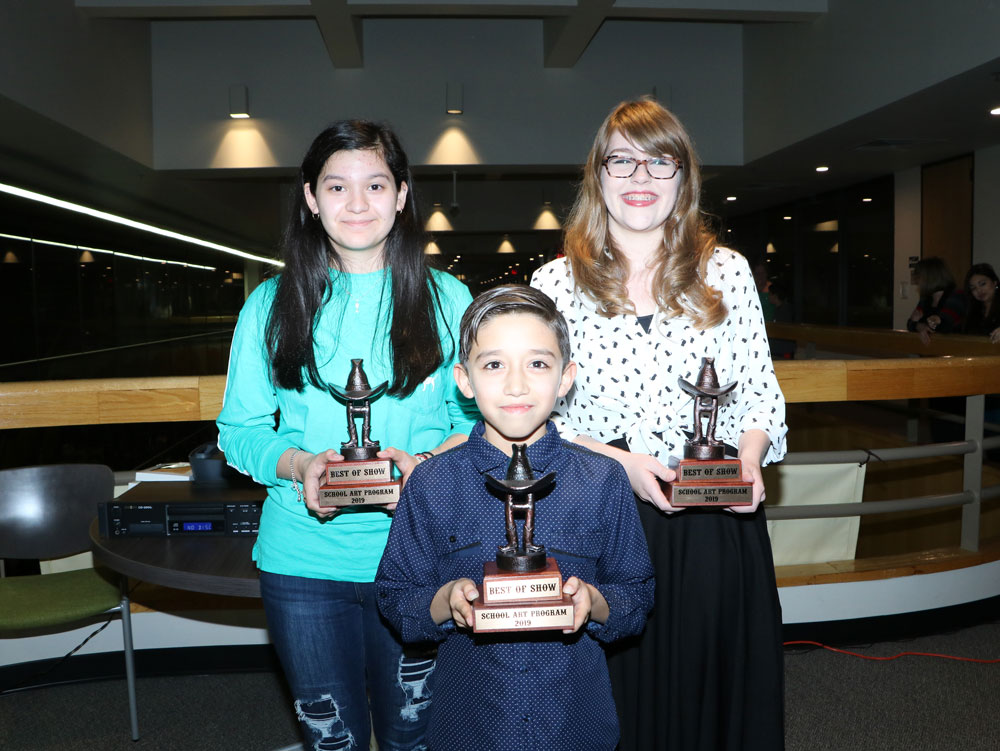 
3 students pose with trophies
