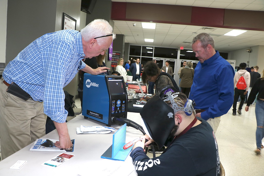 
Eric Farquhar (middle), a senior at Robert E. Lee High School, tries out virtual welding with Gerald Miller (left) of Coastal Welding Supply and Jason Hartman of Miller Welding at their booth at the 7th Annual Career Night for Goose Creek CISD students
