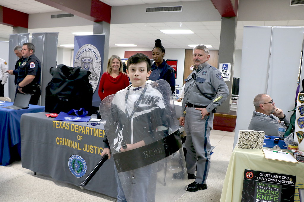
Ian DeTorre, a seventh-grader at Baytown Junior School, tries out a riot shield and baton while discussing career options with representatives (from left) Stacey LeBlanc, senior warden; Officer Robyn Lacy and Captain Bruce Katchmark from the Texas Department of Criminal Justice at Goose Creek CISD’s 7th Annual Career Night at Robert E. Lee High School.
