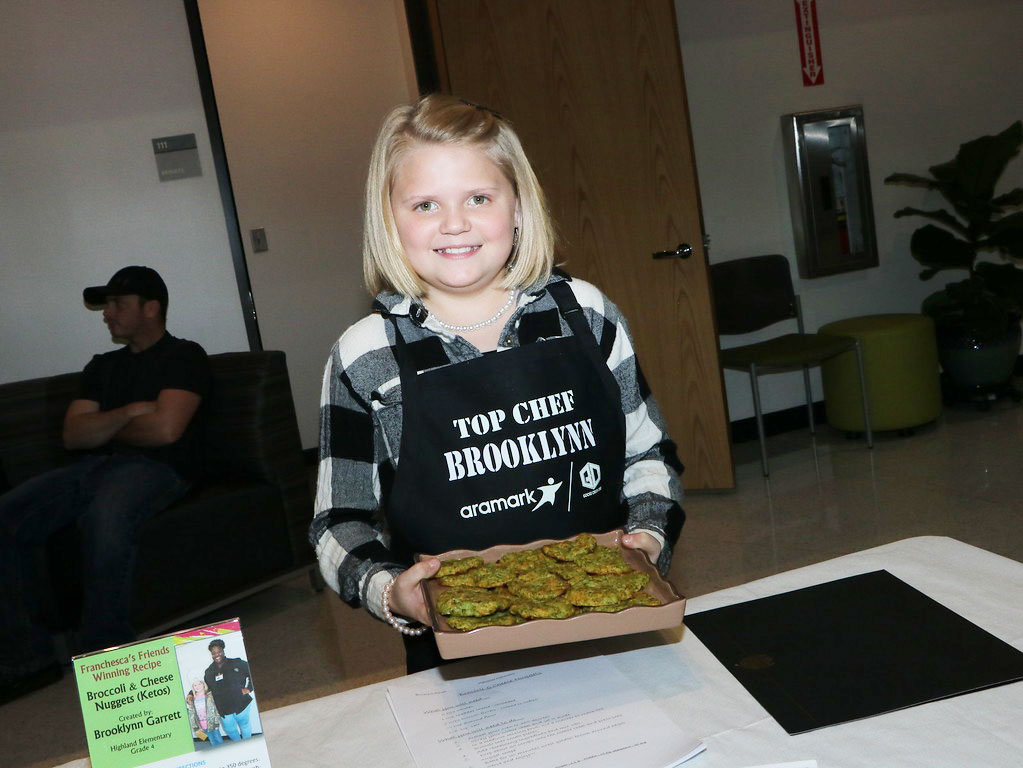 
Brooklynn Garrett, a fourth-grader at Highlands Elementary, shows off her Broccoli and Cheese Nuggets (Ketos), a recipe that was a winner in the Franchesca’s Friends: Farm Fresh Texas Produce Recipe Contest. The competition was a challenge from Chef Franchesca Bland of the Goose Creek CISD Nutrition Services Department for fourth and fifth-grade students to create healthy recipes using Texas produce. Students shared their creations before a recent meeting of the Goose Creek CISD board of trustees.

