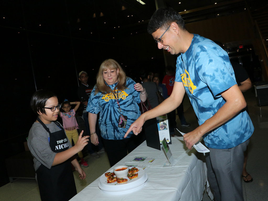 
Nicolas Llanes (left), a fifth-grader from Ashbel Smith Elementary, tells Katherine Cruz, principal, and Luis Munoz, assistant principal, about his recipe for Apache Pizzas, which was a winning recipe in the Franchesca’s Friend: Farm Fresh Texas Produce Recipe Contest.
