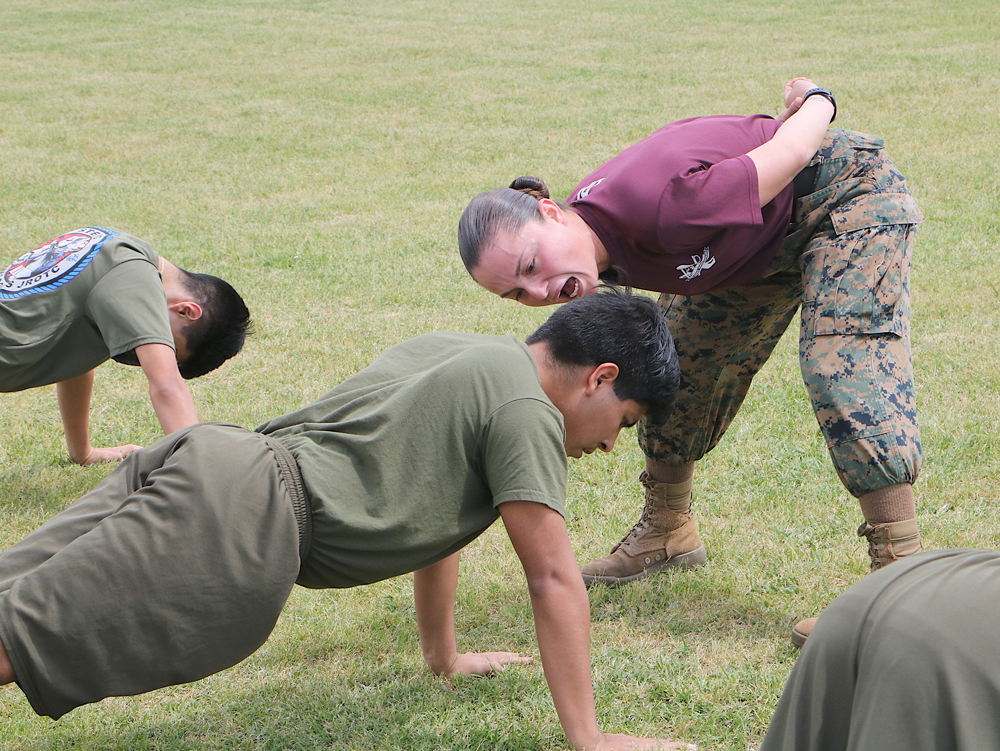
SSgt Michelle Contreras (right), keeps Cadet Angel Alvarado focused as she assists local Marine recruiter SSgt Christopher Baez by taking Ross S. Sterling High School MCJROTC cadets through some of the Daily 17, a routine of exercises performed by recruits at boot camp. SSgt Contreras, originally from California, has been a Marine since 2011 and has been deployed all over the Middle East.
