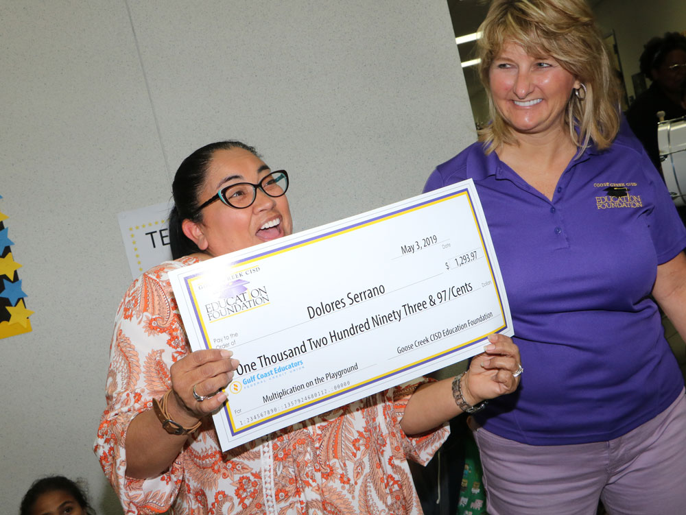
Delores Serrano, a teacher at Carver Elementary, receives a grant for $1,293.97 for “Multiplication on the Playground” from Gena Hutto, secretary of the Goose Creek CISD Education Foundation, during a visit from the Grant Surprise Patrol.
