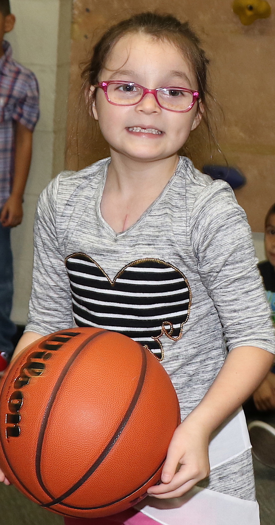 student holds basketball