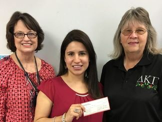  Student accepts a Grants-In-Aid  check from Kathy Littlefield (left) and Karen Stephens from the Gamma Nu Chapter of the Delta Kappa Gamma Society International.  