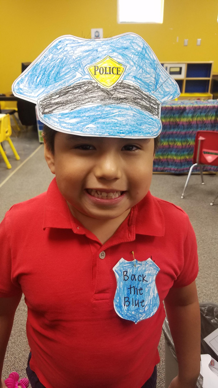  A kindergarten student at Bowie Elementary, shows off the police cap and badge he created to Back the Blue. 