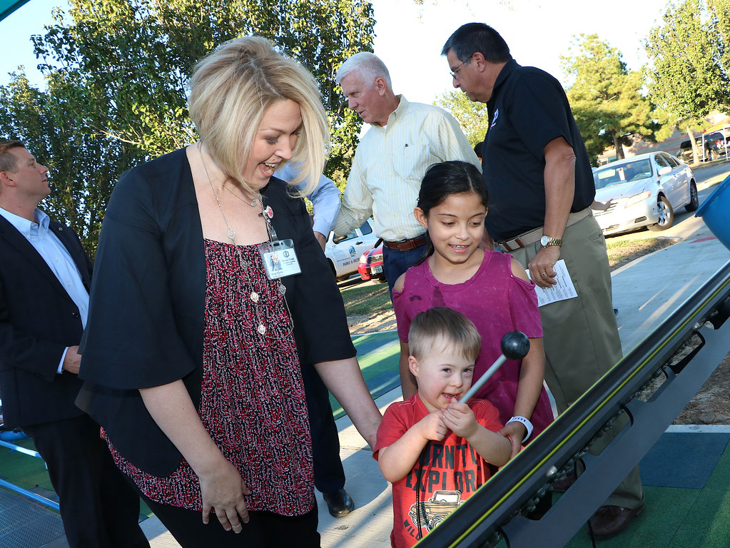  Mary Beebe (left), principal at Travis Elementary and Sadie Garcia (right) help Nolan Hakemack (front) make sounds with equipment at the recent ribbon cutting for the William B. Travis Park Inclusive Playground, a project by the City of Baytown, Goose Creek CISD, Rotary Club of Baytown and Kiwanis Club of Baytown. The park features equipment adapted for special needs children. 