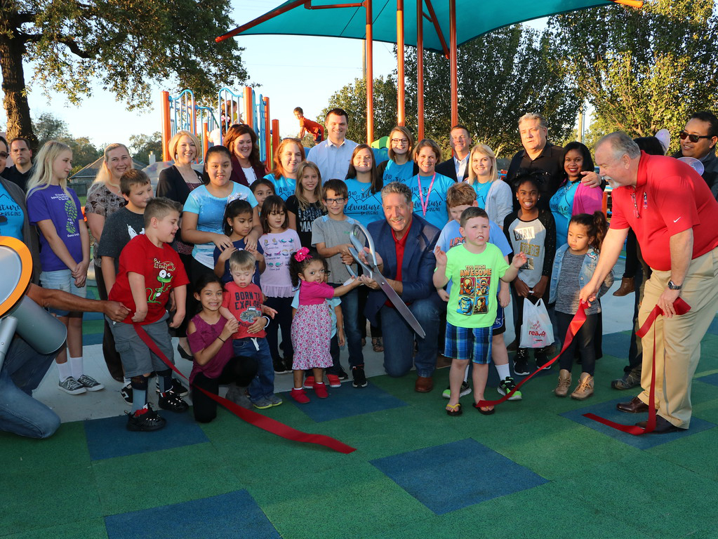  Mayor Steve DonCarlos (right) and Goose Creek CISD Superintendent Randal O’Brien (front, middle) help (front, from left) Sadie Garcia, Nolan Hakemack, Deaken Ailshire, Megan Moody, Mason Pagett, Ashley Paz Turcious, Mason McCallister, Amber Rico, Sadie Garcia and Kennedy Hawkins, along with Travis Elementary staff, cut the ribbon on the newly constructed William B. Travis Park Inclusive Playground. The playground, adapted to allow special needs children to also participate, was constructed and landscaped through the cumulative efforts of the City of Baytown, Goose Creek CISD, Rotary Club of Baytown and Kiwanis Club of Baytown. Also pictured are staff from the City of Baytown and the Goose Creek CISD Special Education Department. 