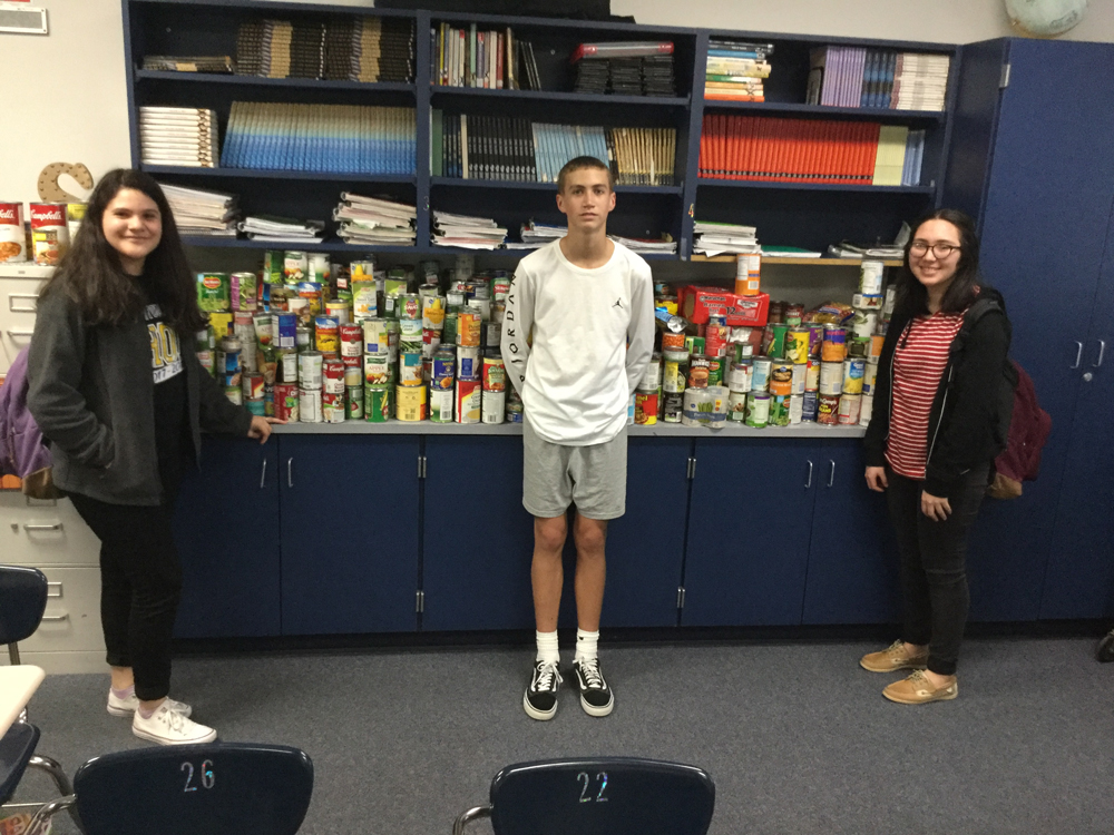  (from left) Alondra Martinez, Drake Jackson and Daisy Medina show off the 1,511 canned goods collected by the Cedar Bayou Junior School Student Council for Thanksgiving food baskets and to donate to the food drive at Ross S. Sterling High School. Christy Stanley and Taylor Barnett are CBJ Student Council sponsors. 