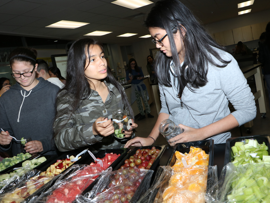  IMPACT ECHS Spanish Club students (from left) Lizzie Osbon, Amy Castillo and Natalie Huskey select fruit and vegetables for their healthy shakes. 