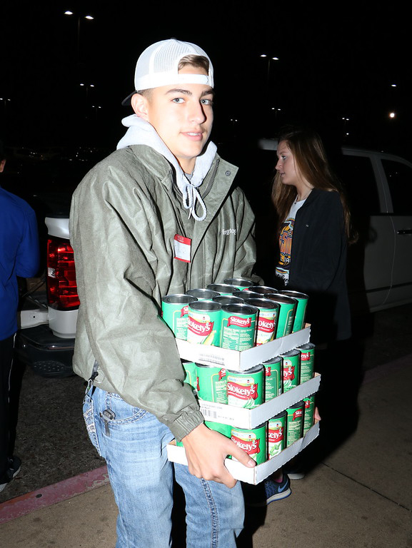  Justin Rodriguez, a student at Ross S. Sterling High School, unloads donations received during the HO HO HO Scavenger Hunt to donate to Channel 13’s Share Your Christmas Food Drive.
