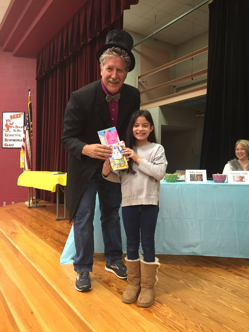  Sadie Garcia, fourth-grader in Mrs. Contreras’ class at Travis Elementary, with Goose Creek CISD superintendent Randal O’Brien, shows off the prizes she won as the first place individual winner in the “Chocolate Tank” competition. The activity was based on the television show “Shark Tank”  and followed up the study of the novel “Charlie and the Chocolate Factory” by Roald Dahl in Mrs. Contreras’ fourth-grade class. After designing a never-before-seen candy that Willy Wonka would want to create and sell, students wrote a persuasive speech and made a poster with a drawing of their candy creation. All teams and individuals presented to a panel of judges, including O’Brien, other administrators and the librarian, and the winners were announced.

