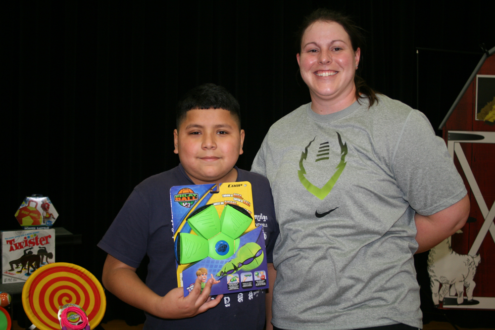 Fourth-grader Christopher Ruiz wins a door prize with Coach Reiss, Carver P.E. teacher, at Carver CATCH Family Night.