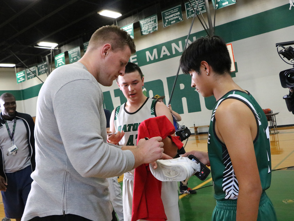 
J. J. Watt signs Daniel Silva’s athletic shoe, while Christian Bienek waits to have him sign a shirt recently when J.J. and a film crew from The Players’ Tribune stopped by Horace Mann Junior School for some footage for a feature they are filming.  Watt’s Foundation donated $10,000 in athletic equipment to the school two years ago. Looking on is Coach Ronald Wells.
