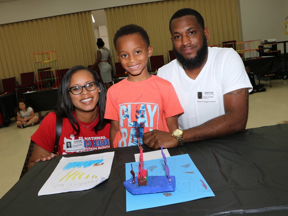 
Lance Jordan II (middle), and his parents Latoya Brown and Lance Jordan, Sr. look at the boat their son created at the recent GATE Showcase at Hopper Primary.
