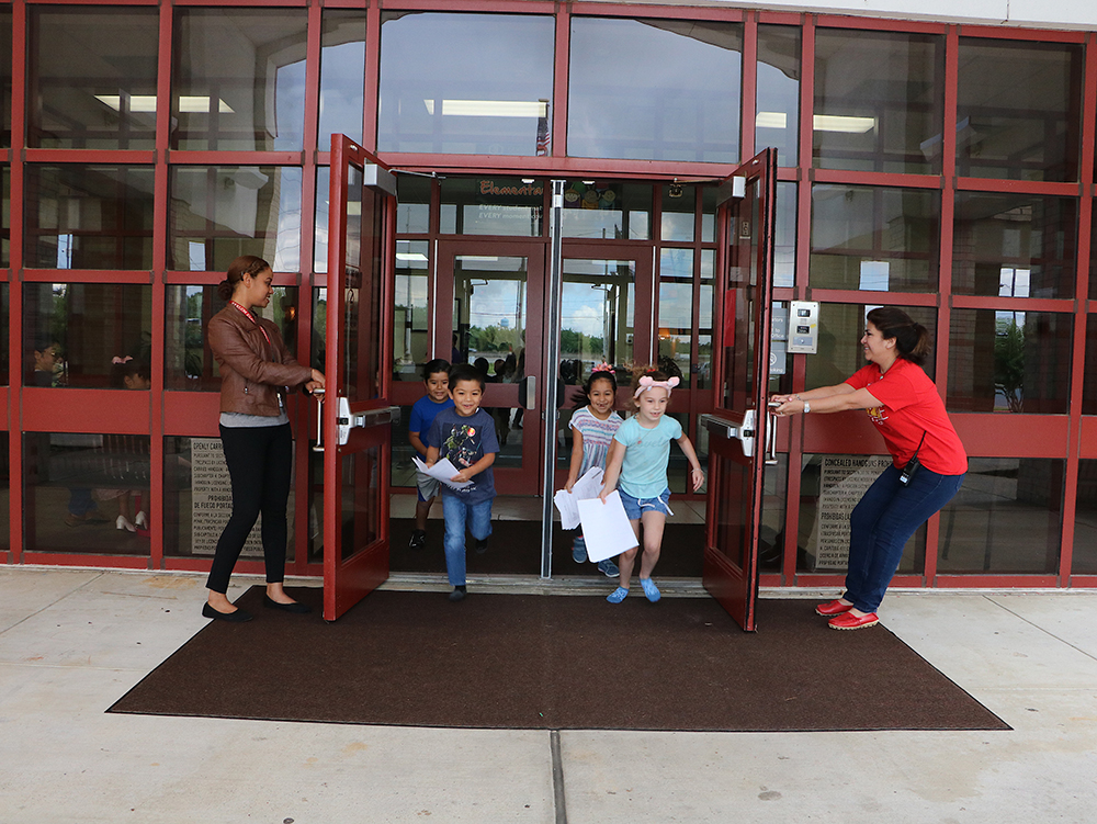  Cyre King (left) and Betty Baca, principal, hold the doors open on the last day of school for Harlem Elementary School students (from left) Miguel Magallon, Christian Formoso, Tania Rodriguez and Ryliegh Sellman.
