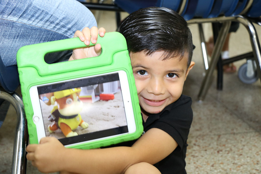 
Adrian Santos uses his tablet while his mother registers him for pre-kindergarten during the three-day registration held at Ross S. Sterling High School.
