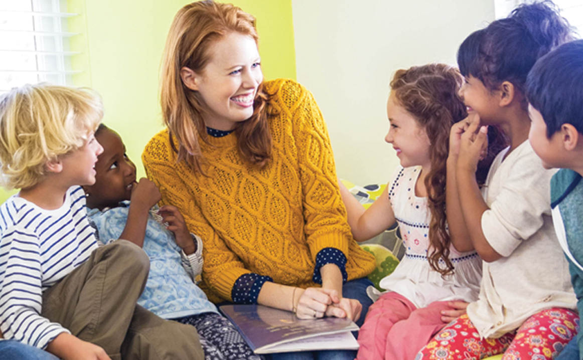 six pre-kinder students listen to their teacher