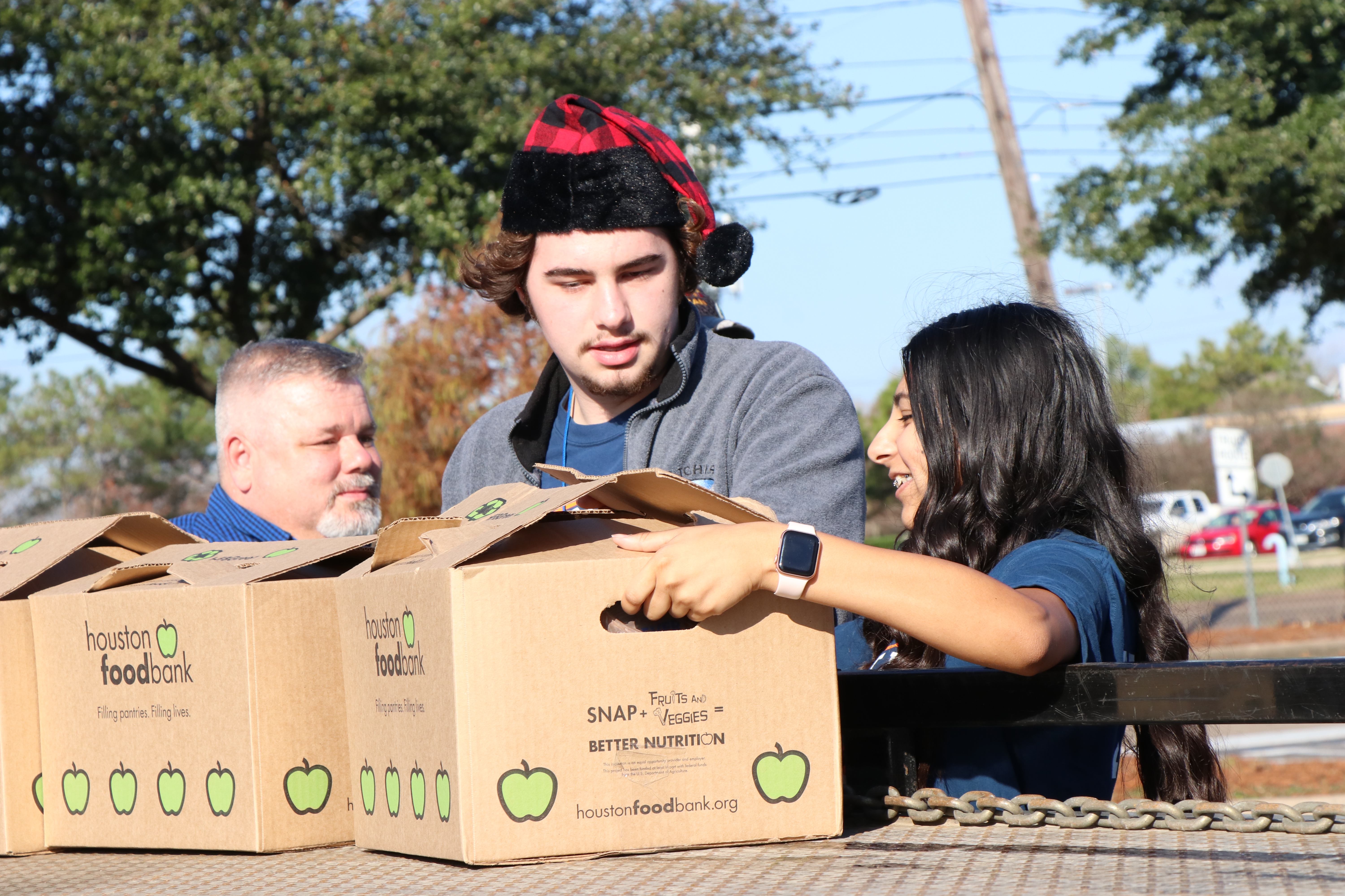 Ross S. Sterling High School PAL, prepare to load boxes of food into a waiting truck