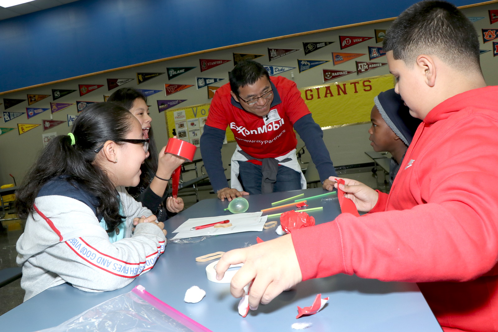 ExxonMobil employee showing students experiment.