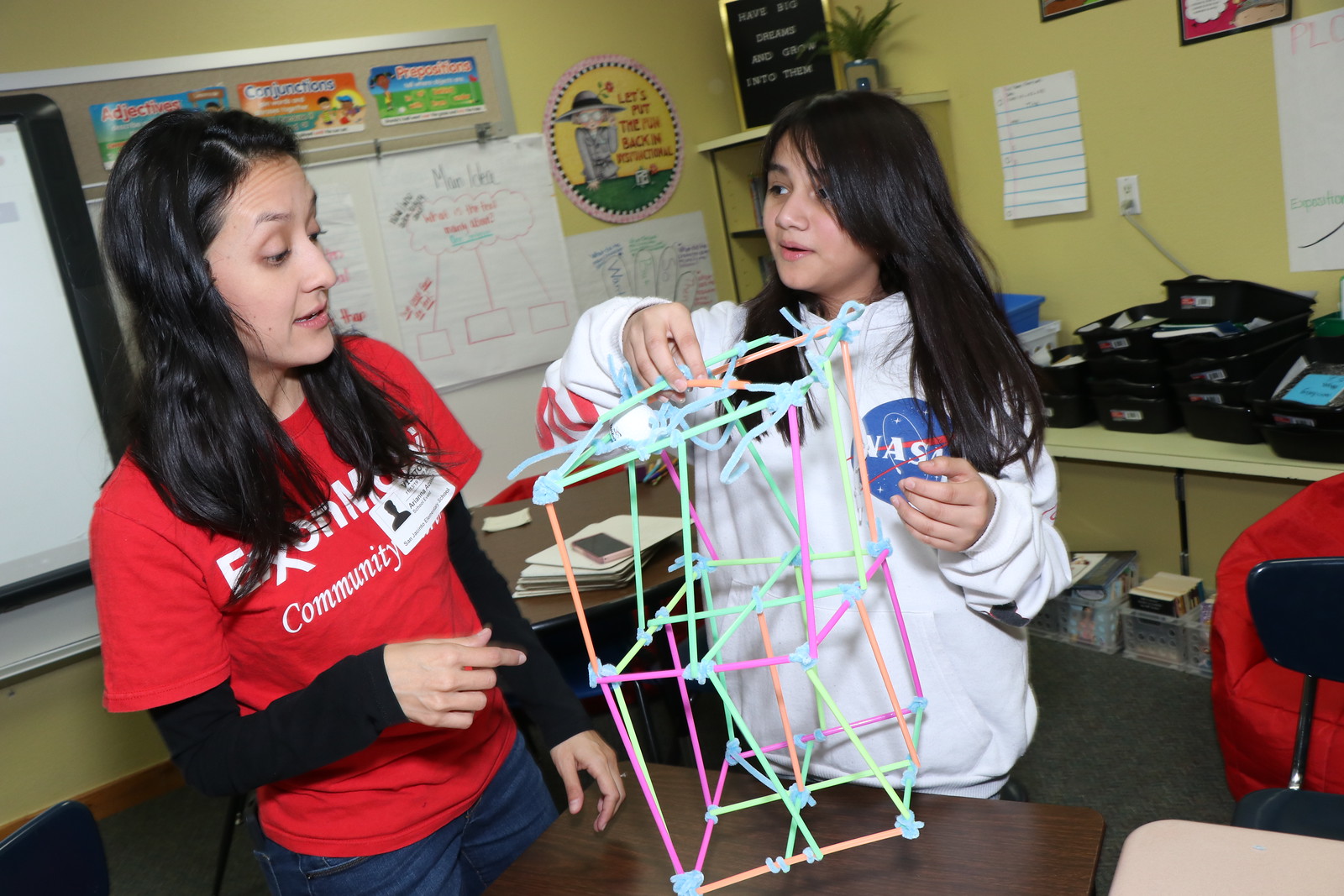 ExxonMobil employee assist with straw experiment.