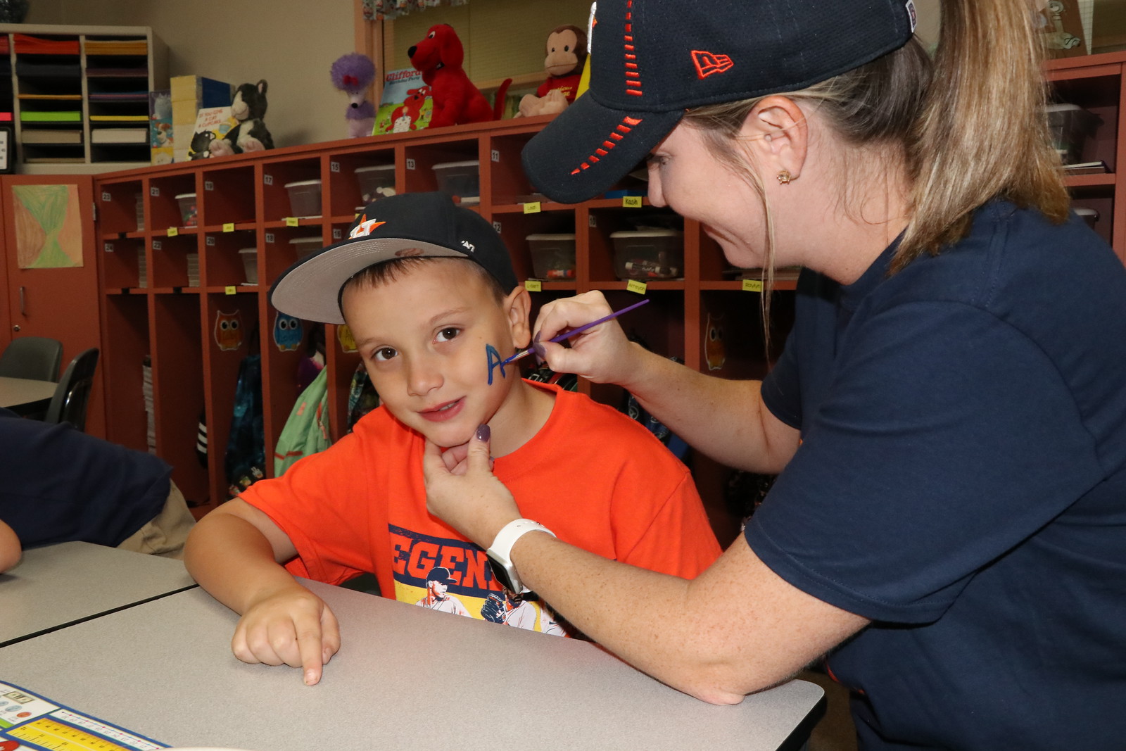 Travis Elementary teacher Amber Wheeler paints Colby Whisler’s face to show his Astros spirit.