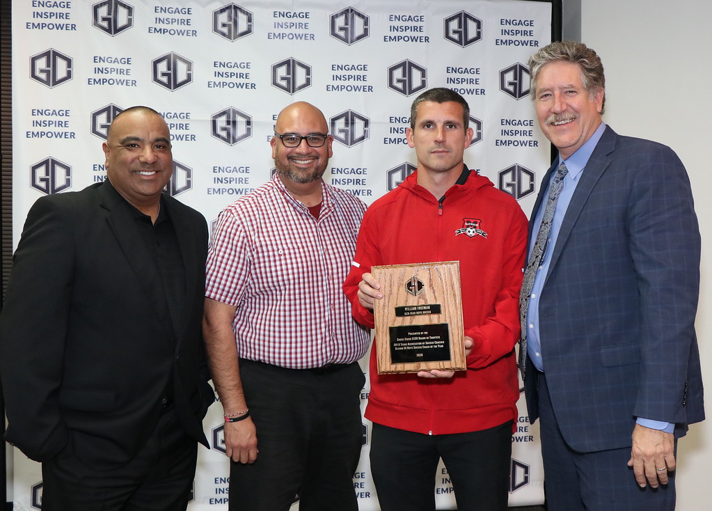 Soccer Coach William Freeman poses with award