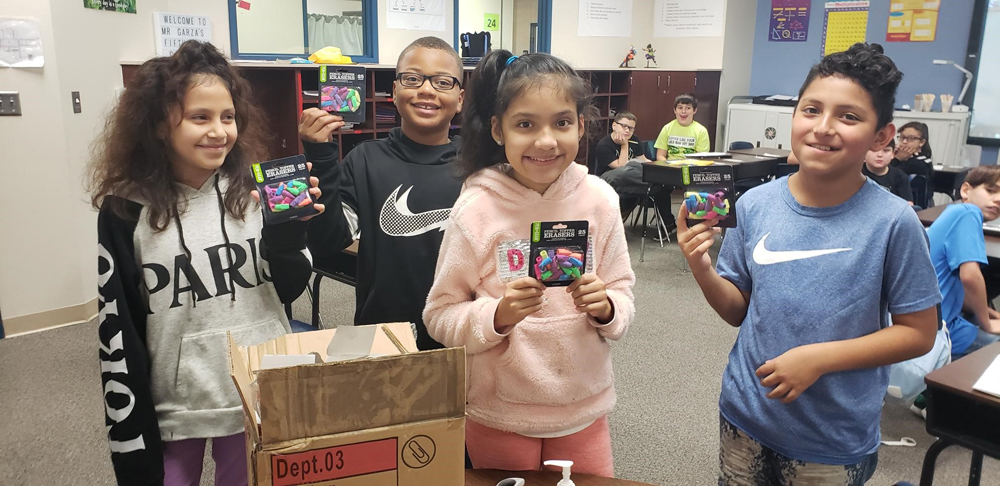 students hold supplies donated by wal-mart