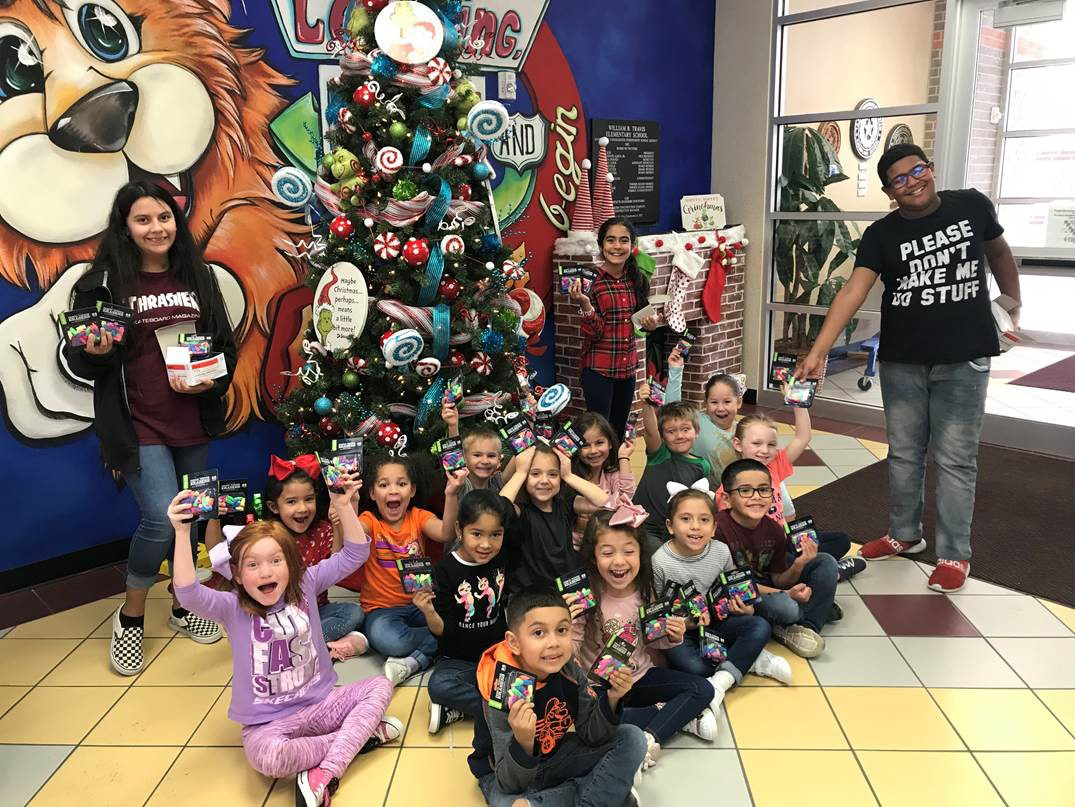 classroom of students hold supplies donated by wal-mart