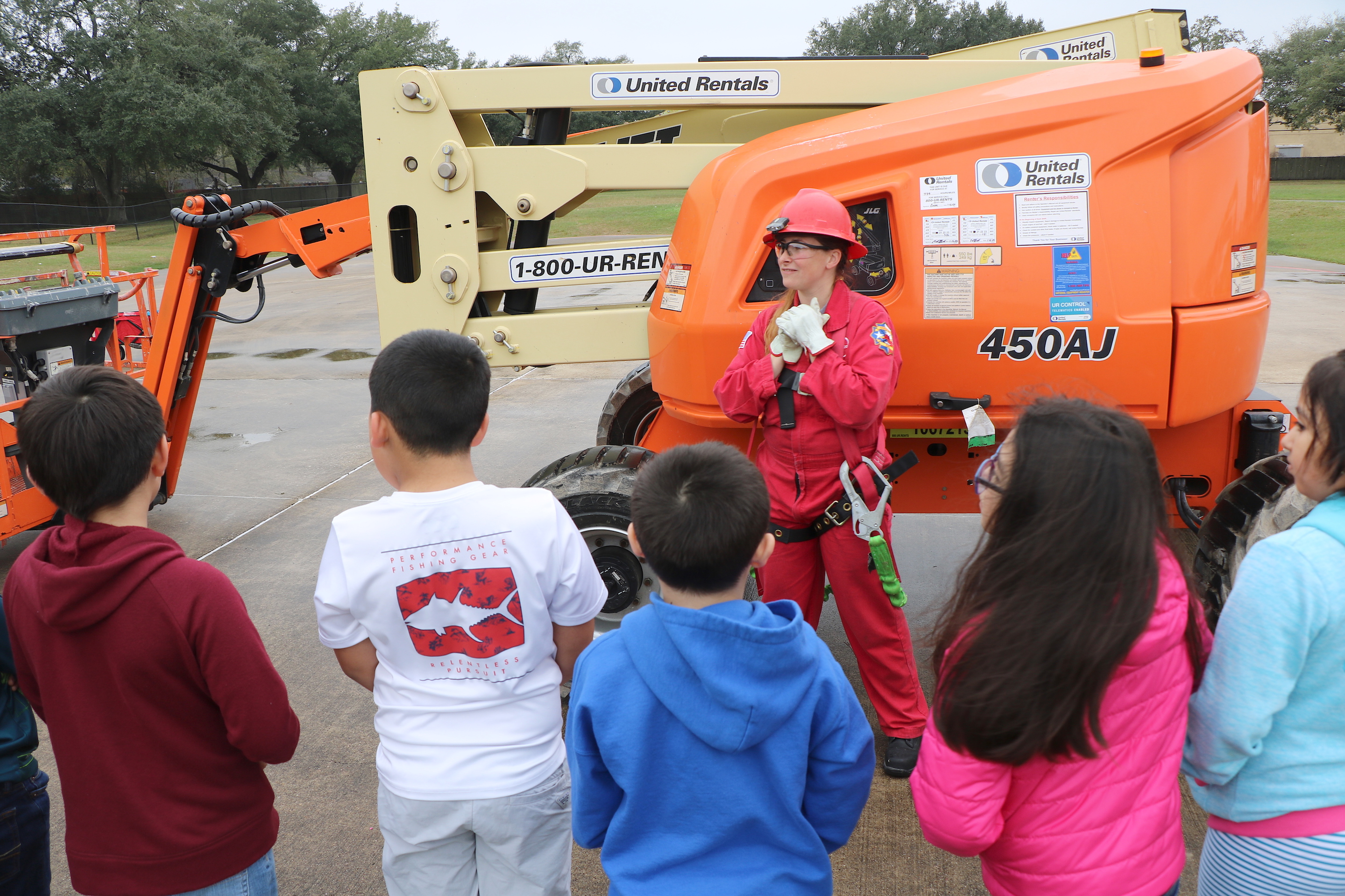 City worker talks to students about equipment.