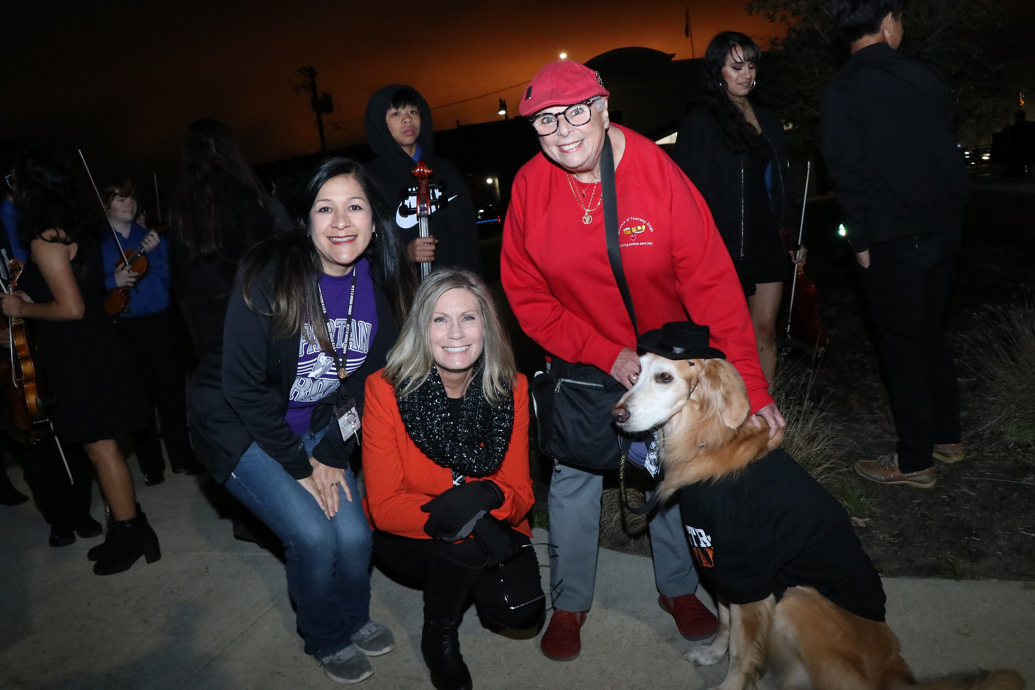 Community members pose with Rebel the therapy dog