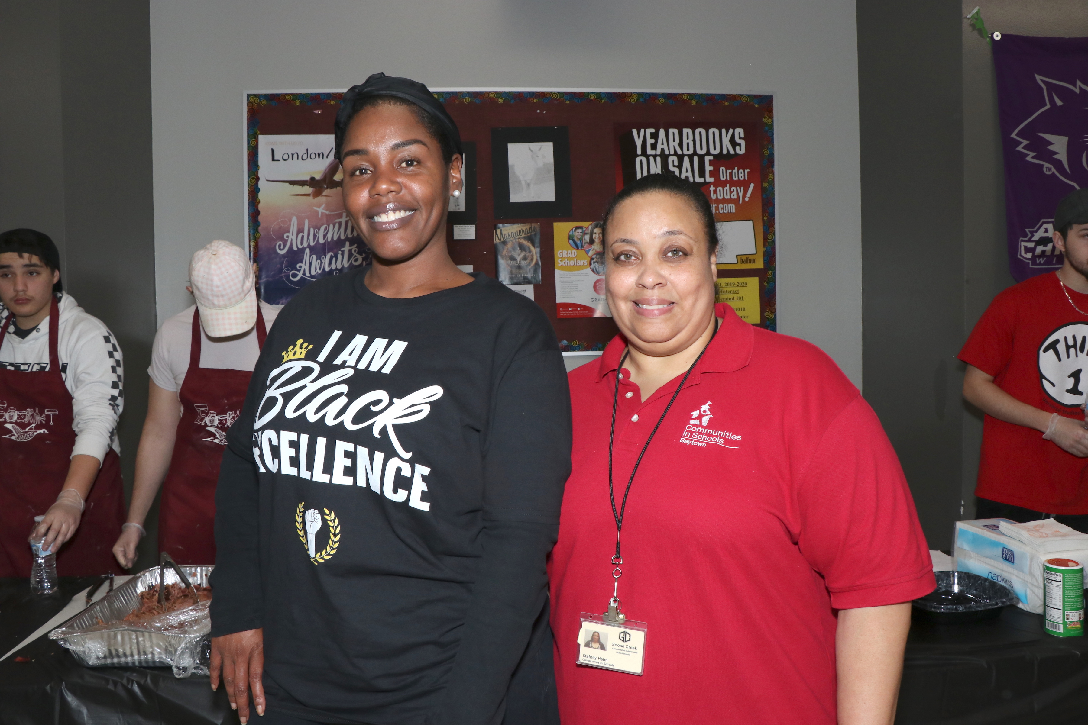 Staff pose in front of food line