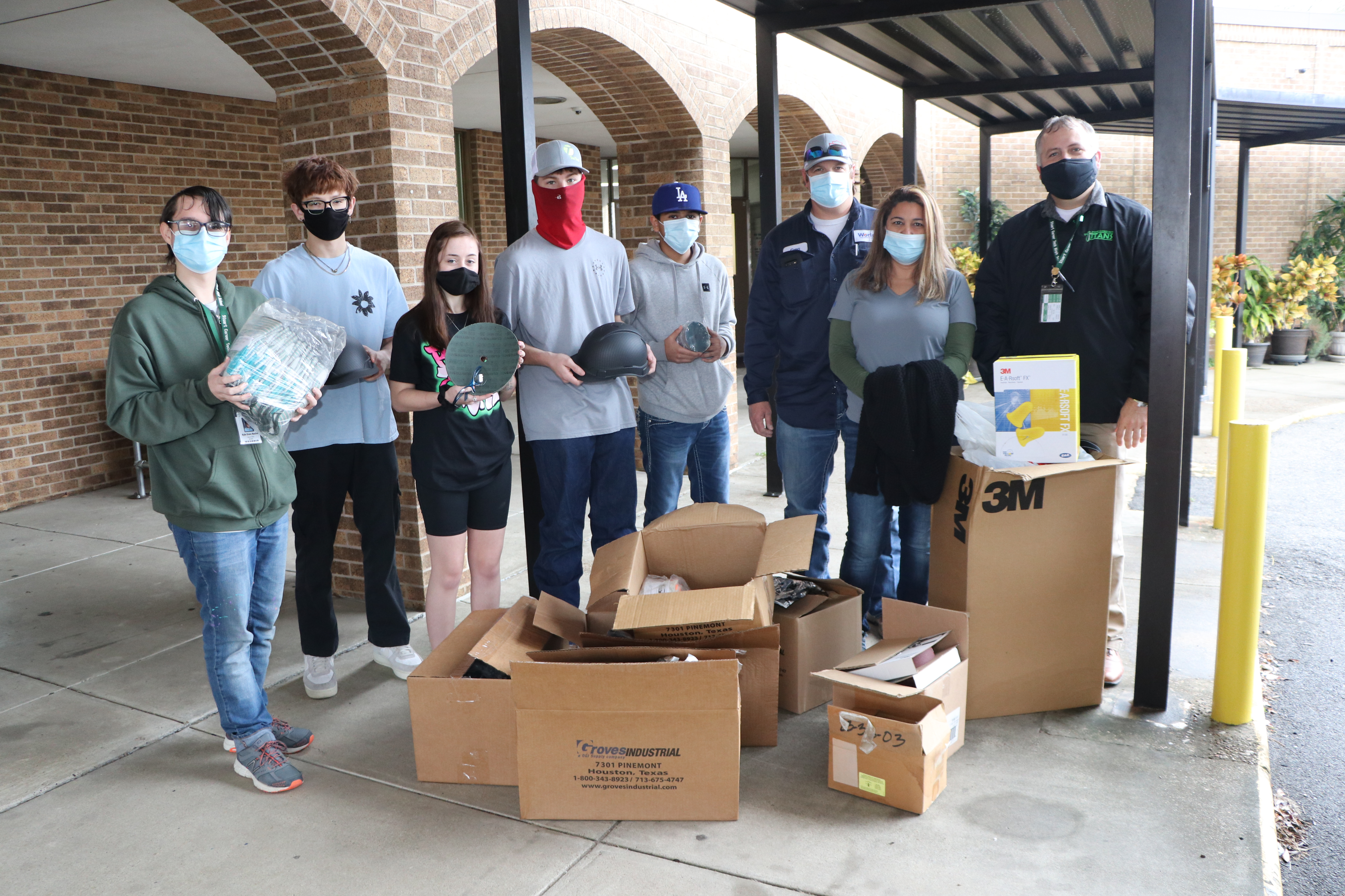 Students pose with Worley staff, principal and donations