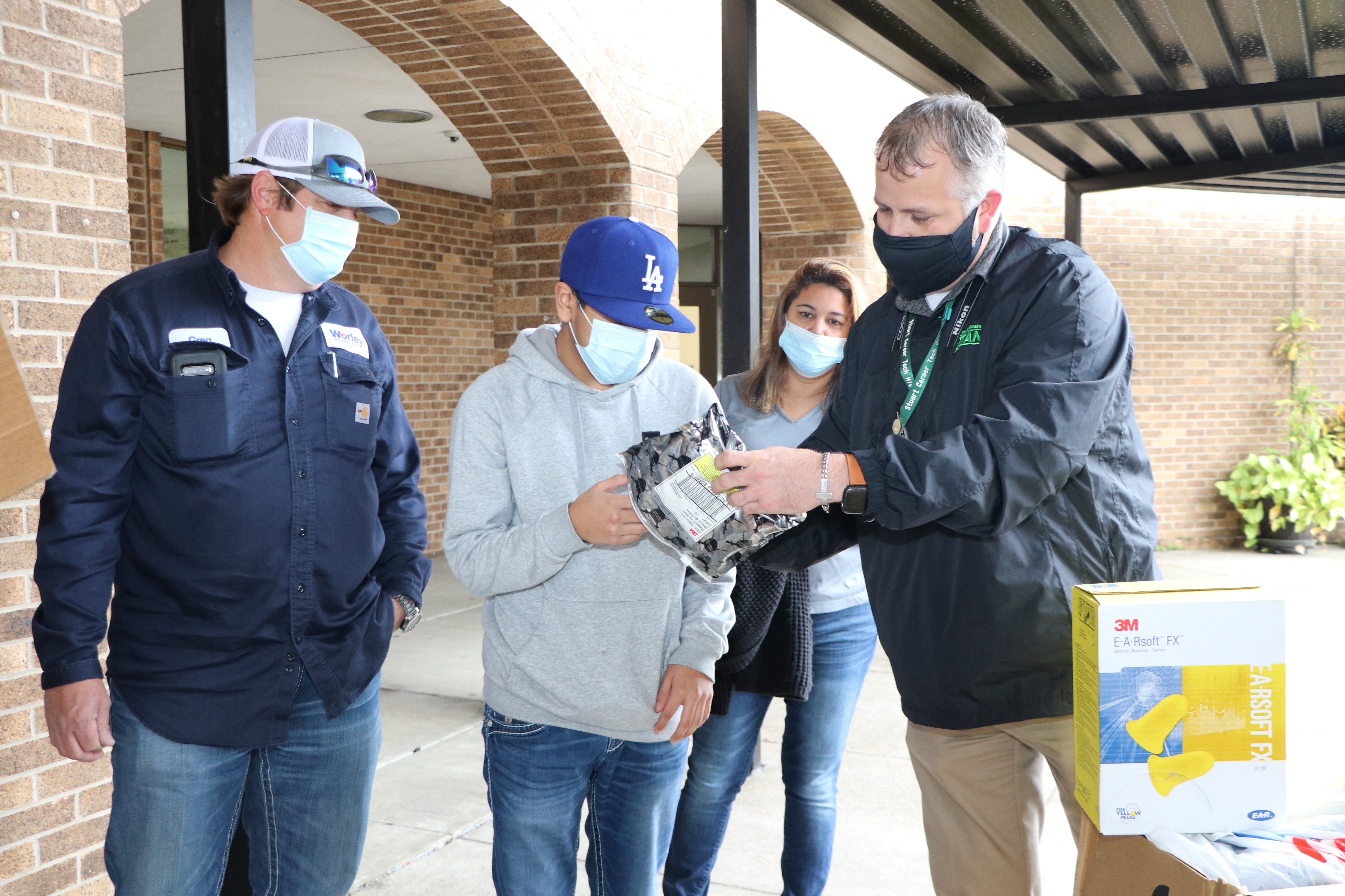 Principal and Worley staff look at donations with student