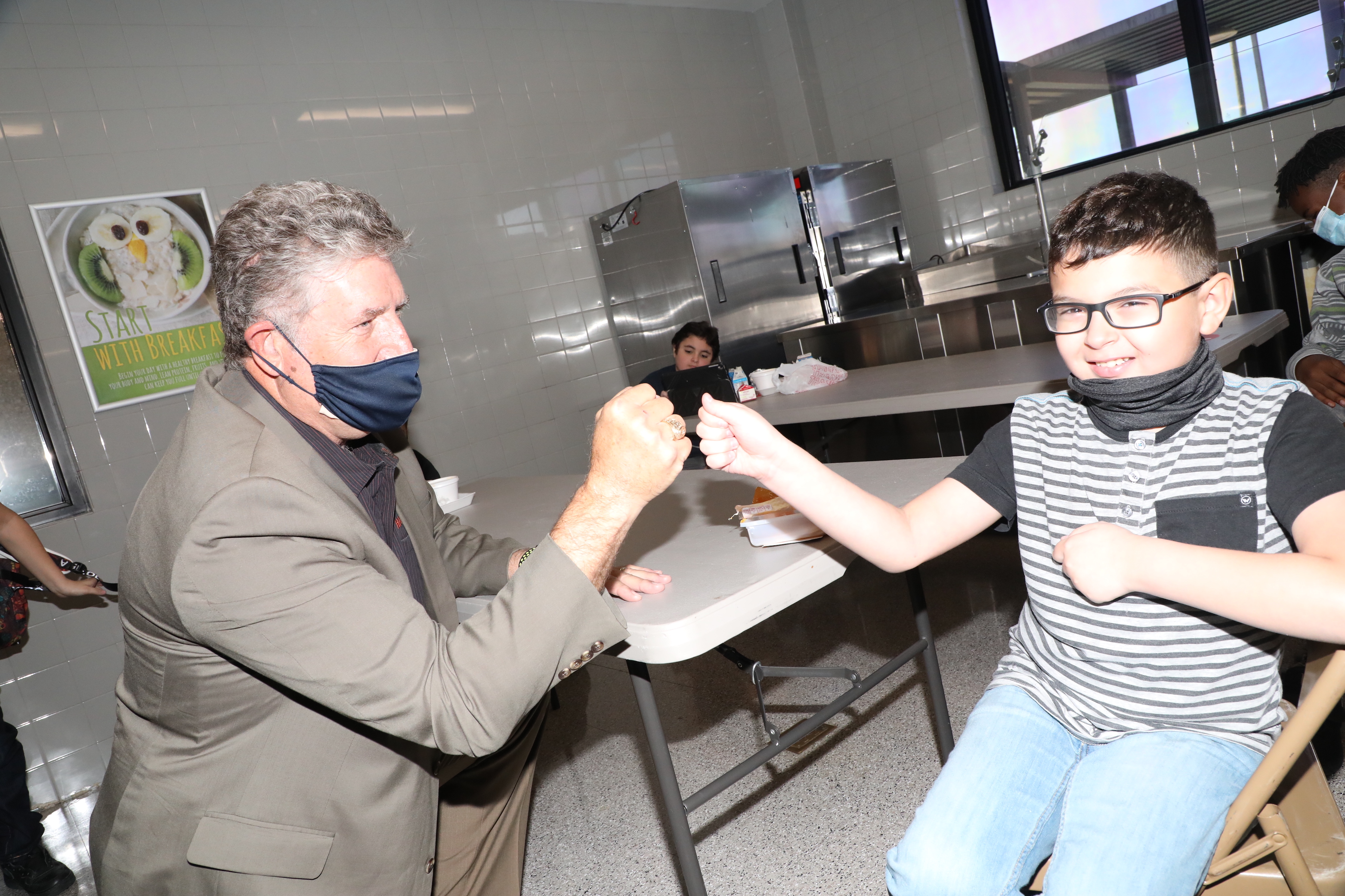 Dr. Randal O Brien fist bumps gentry junior student Ashton Mexas