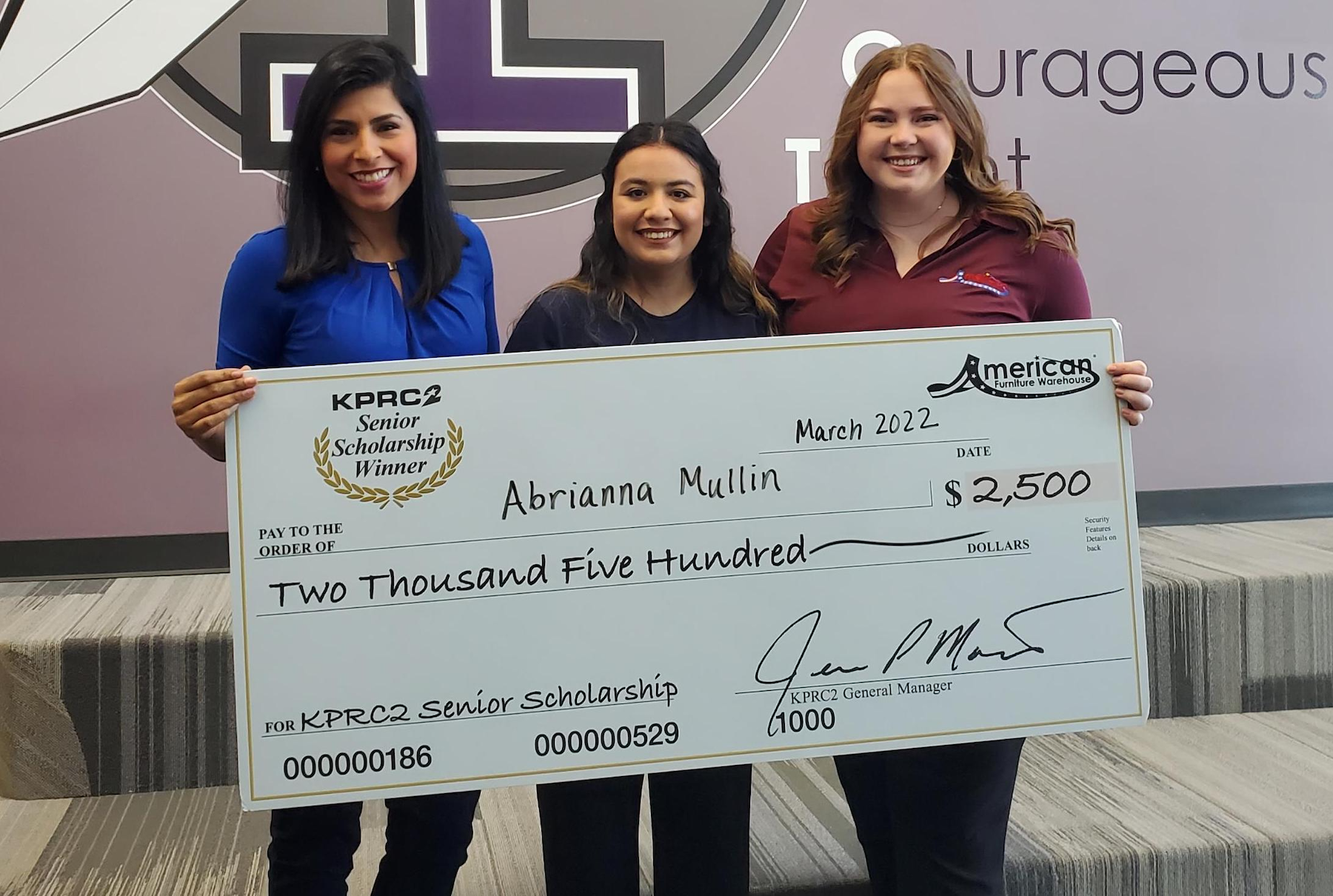 Abrianna Mullin poses holding giant check with sponsors