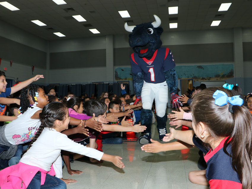 Toro with Texans runs through the crowd at De Zavala Elementary before the “Toro Takes the Bull Out of Bullying” program.