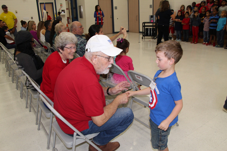 student shakes hand of older man