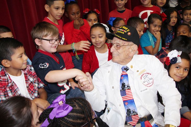 Young student shakes hands of United States veteran.