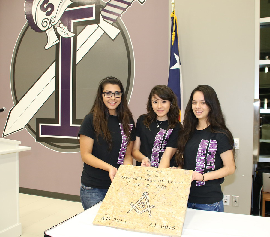 3 students holding cornerstone