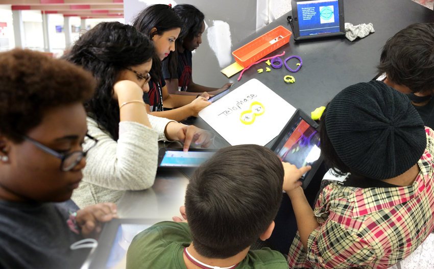 Students charge electronic devices and work on homework