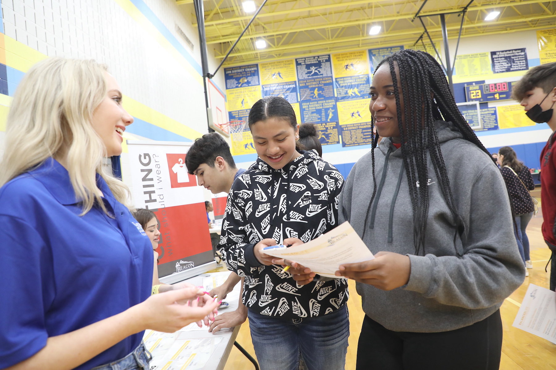 students speak with booth representative about cost of living