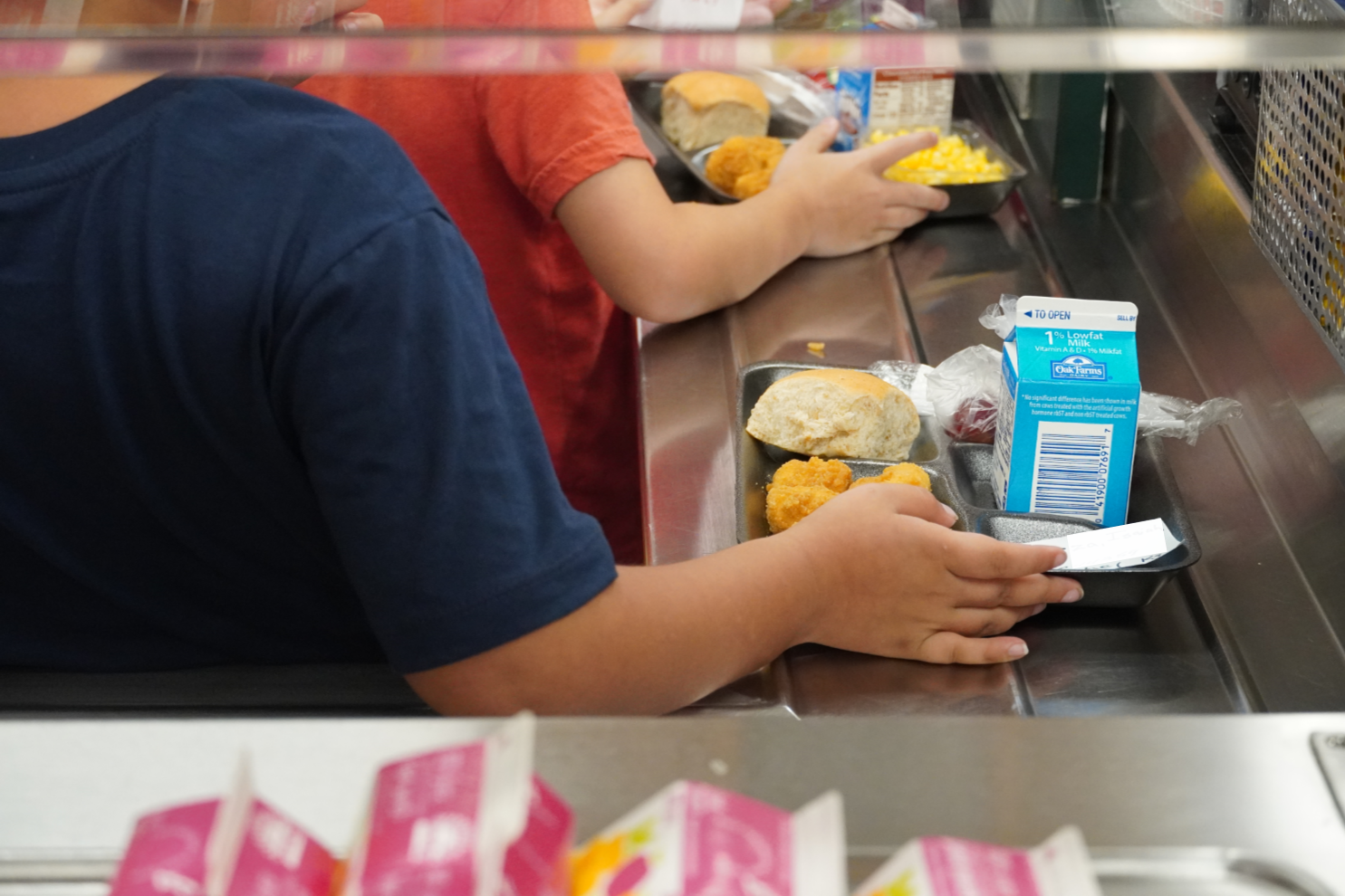 students move lunch trays across ledge